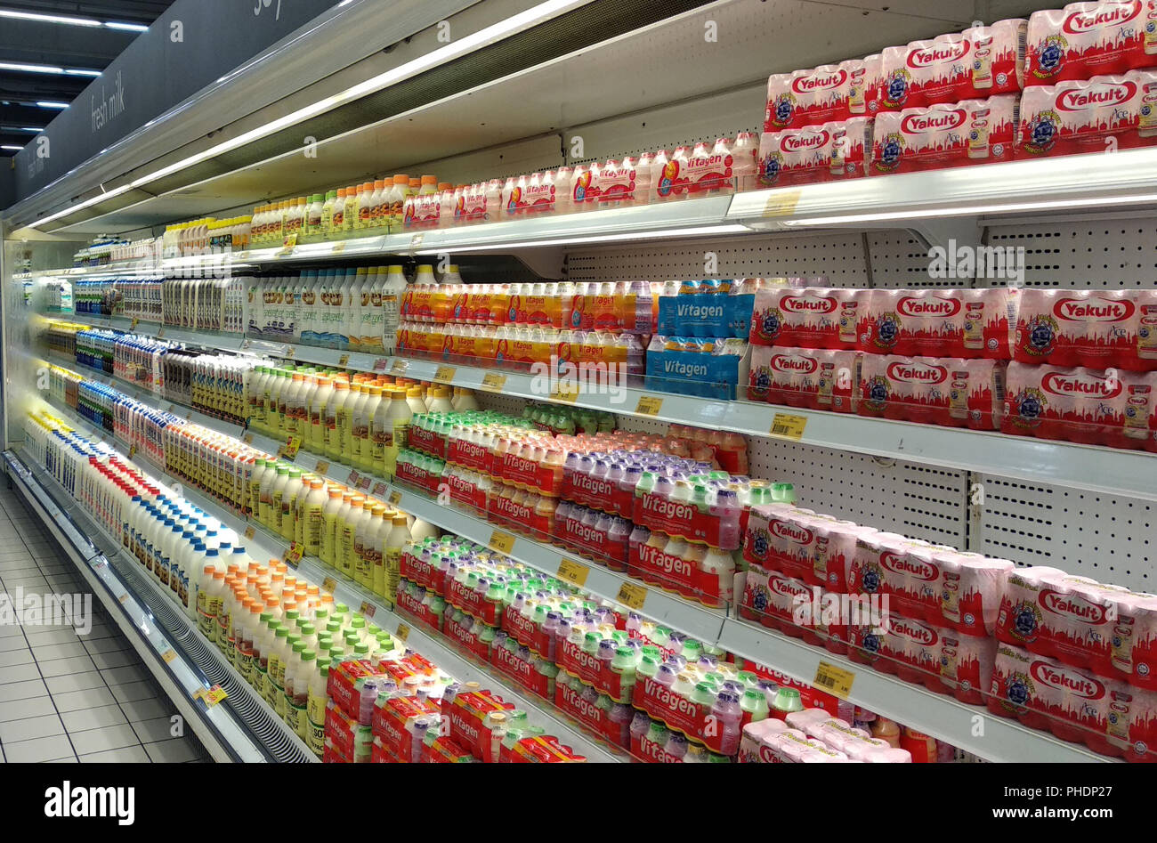Latte contenente prebiotici e batteri buoni confezionati in bottiglie piccole e visualizzati sugli scaffali del supermercato per la vendita. Foto Stock