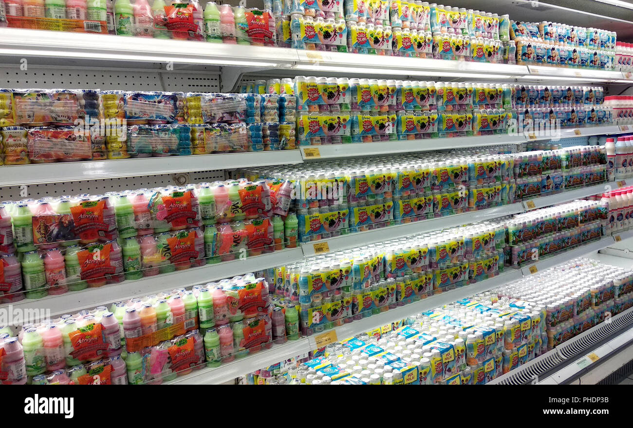 Latte contenente prebiotici e batteri buoni confezionati in bottiglie piccole e visualizzati sugli scaffali del supermercato per la vendita. Foto Stock