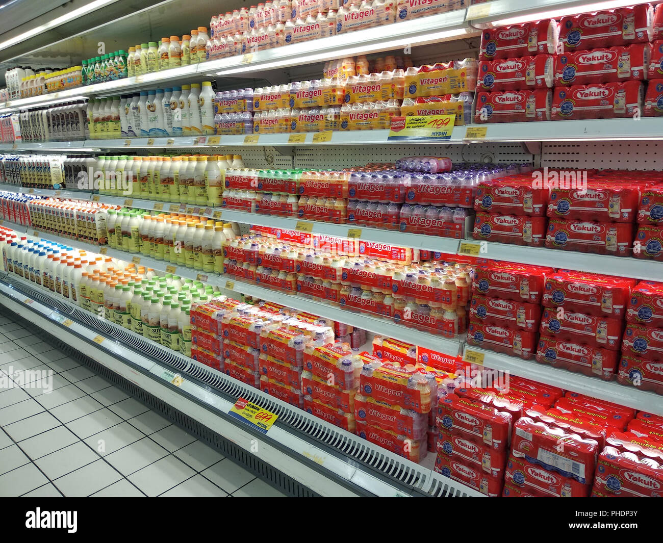 Latte contenente prebiotici e batteri buoni confezionati in bottiglie piccole e visualizzati sugli scaffali del supermercato per la vendita. Foto Stock