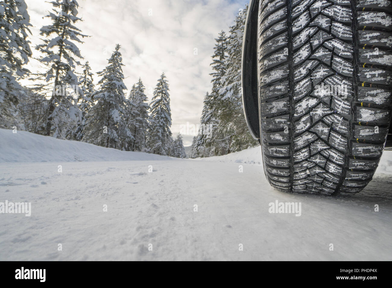 Dettaglio della ruota su strada con ghiaccio e neve Foto Stock