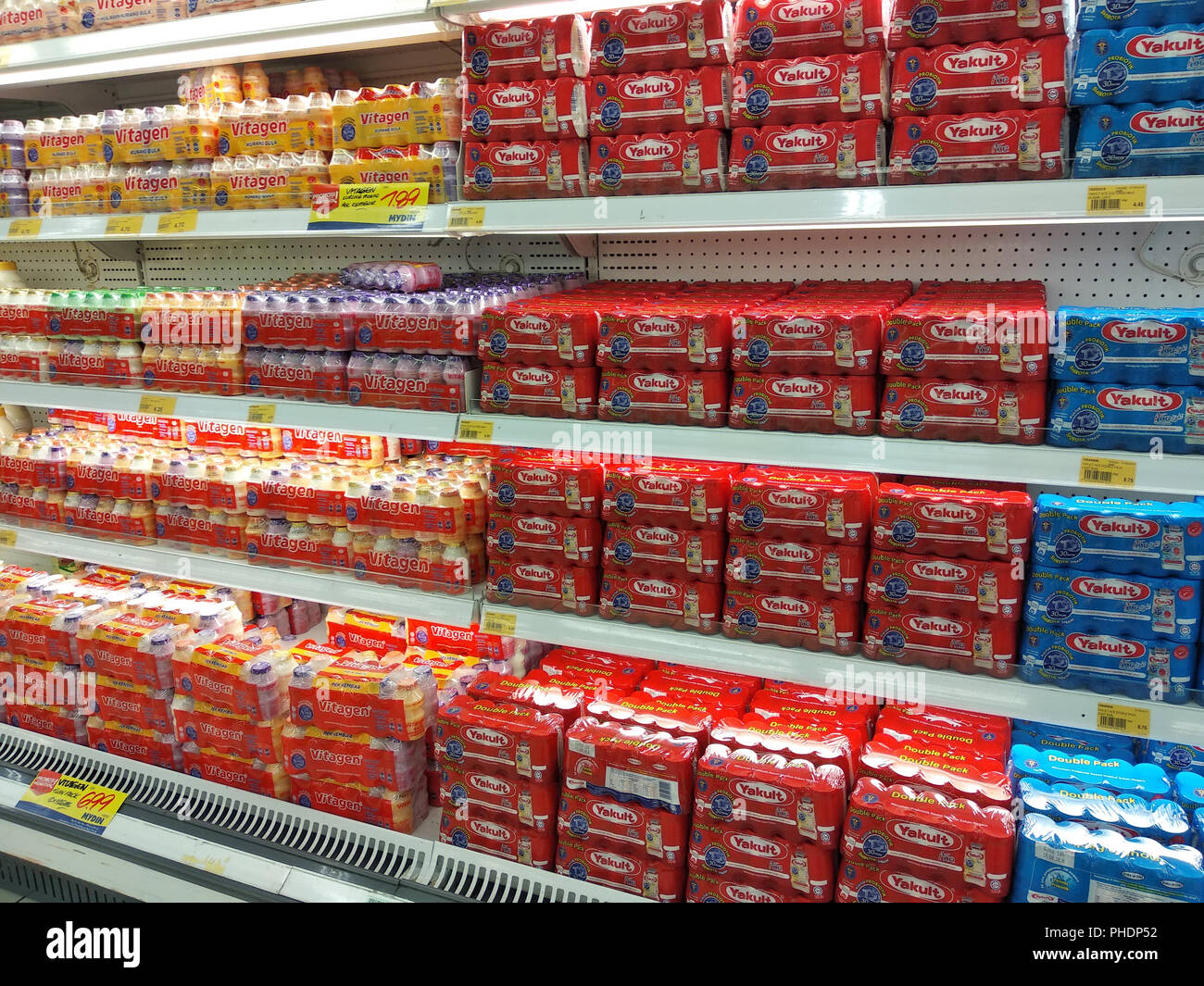 Latte contenente prebiotici e batteri buoni confezionati in bottiglie piccole e visualizzati sugli scaffali del supermercato per la vendita. Foto Stock