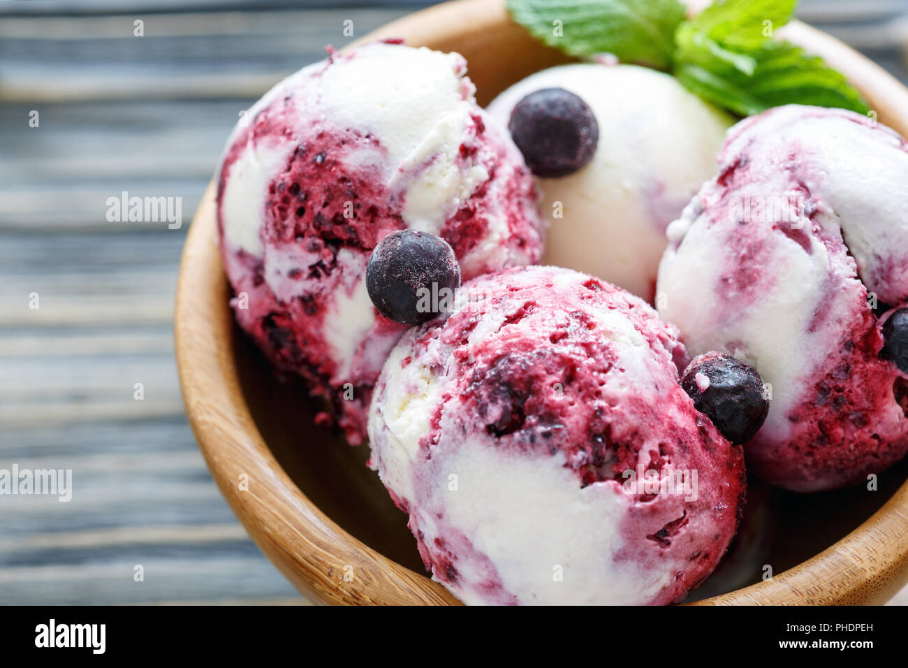 Gelato alla crema con il ribes nero in ciotola di legno. Foto Stock