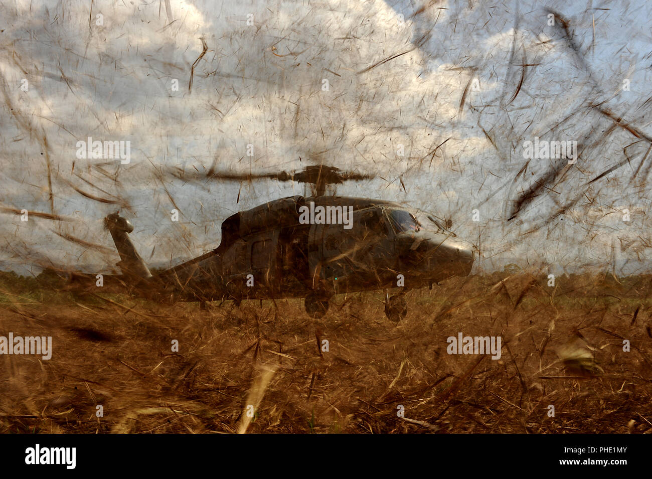 Un U.S. Navy HH-60 si prepara a terra in un campo e pick up U.S. Air Force Combat Controller e U.S. Esercito esploratori conducendo una zona di caduta di indagine per la futura caduta aria siti su gennaio 24, 2010 a Port-au-Prince, Haiti durante il funzionamento risposta unitaria. Foto Stock