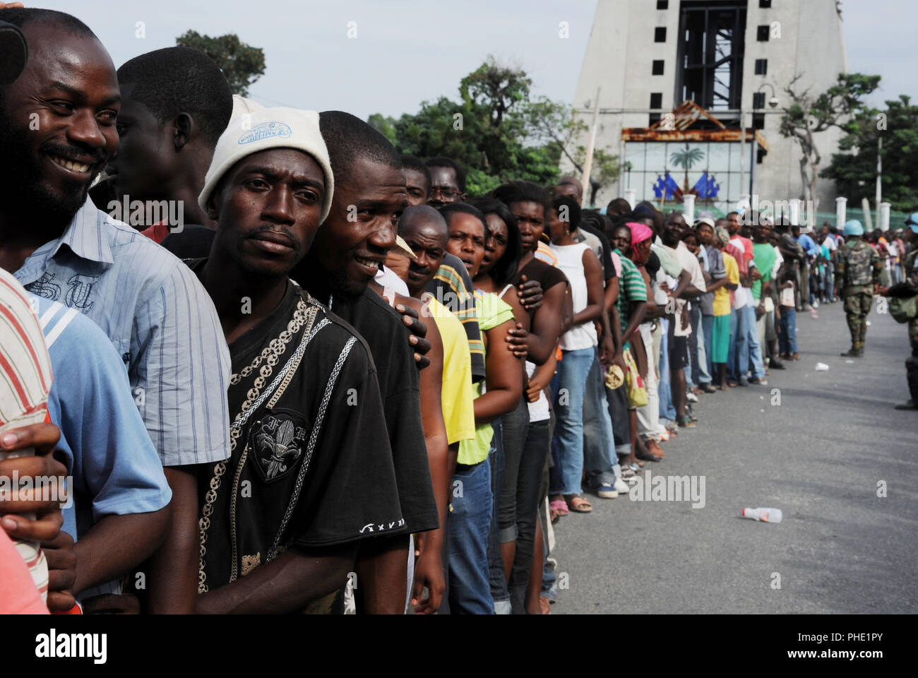Gli haitiani line up per i sacchi di riso di fronte al Palazzo Presidenziale di Port au Prince, Haiti il 25 gennaio, 2010. Haiti è stata devastata da un terremoto di magnitudine 7.0 su GEN12, 2010. (U.S. Air Force foto di Tech. Sgt. Prentice Colter) (rilasciato) Foto Stock