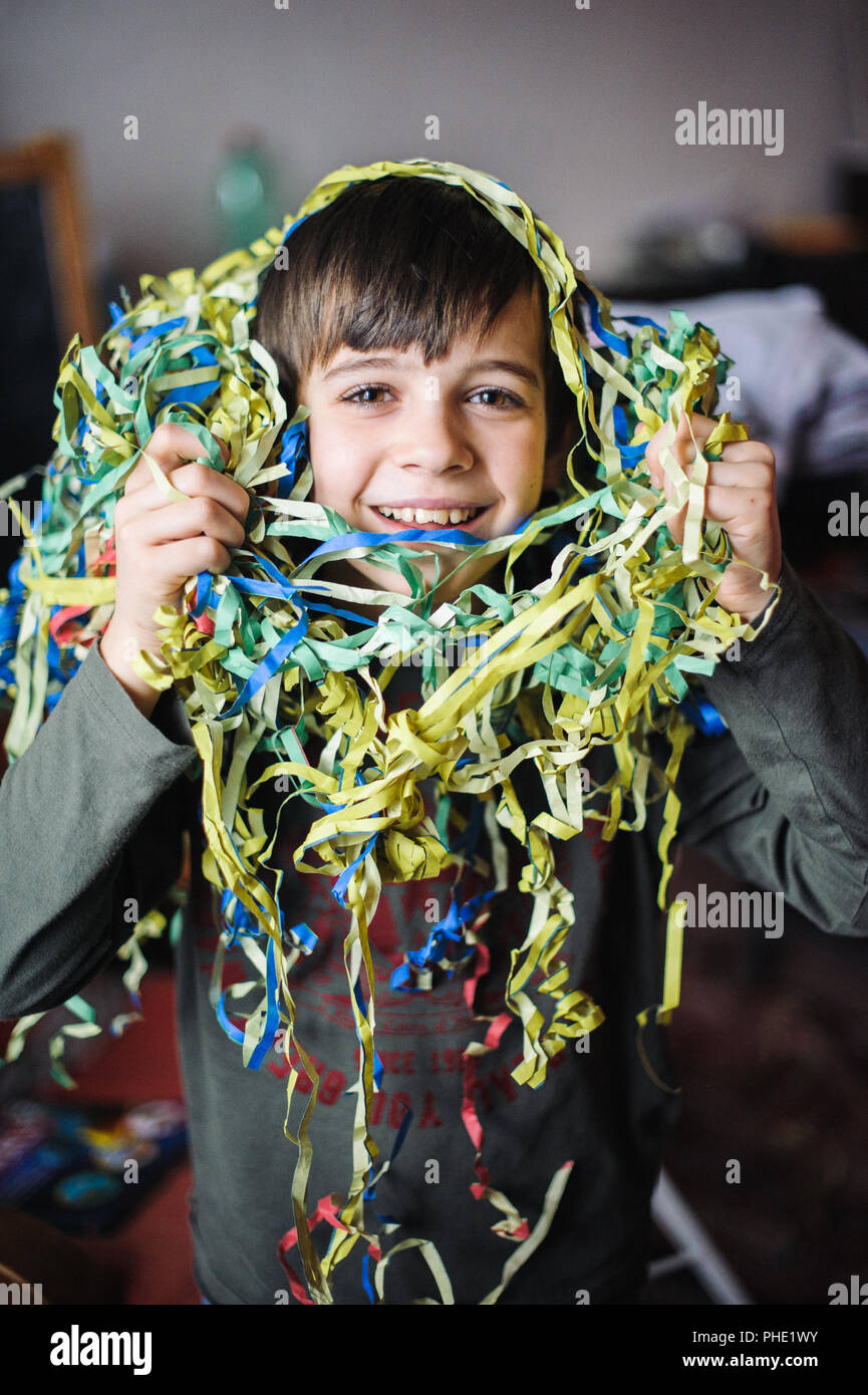 Bambino con streamers intorno al collo e testa Foto Stock