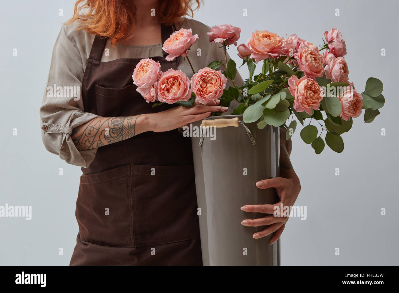 Ragazza con un vaso con un mazzo di rose Foto Stock