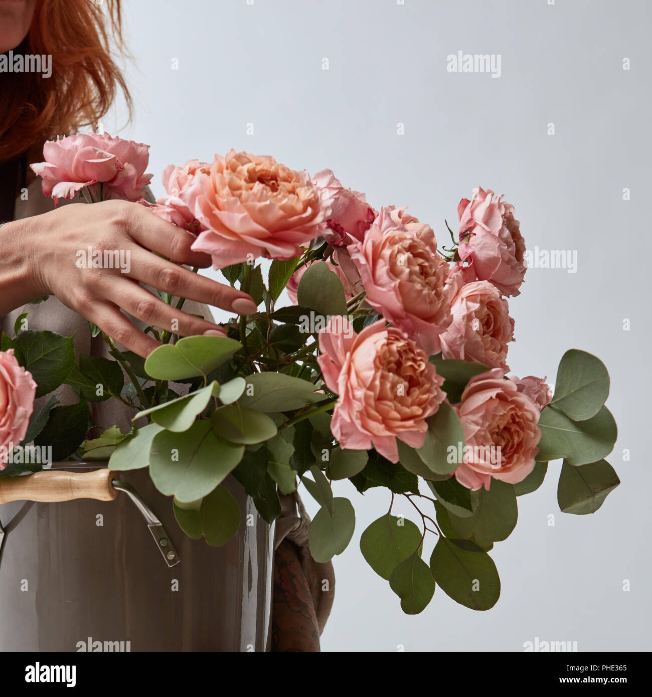 Ragazza con un vaso con un mazzo di rose Foto Stock