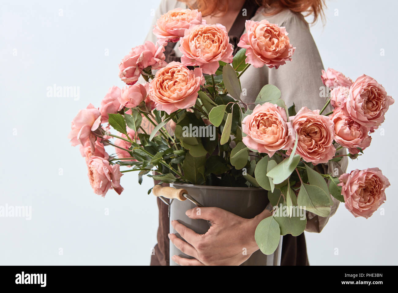 Ragazza con un vaso con un mazzo di rose Foto Stock