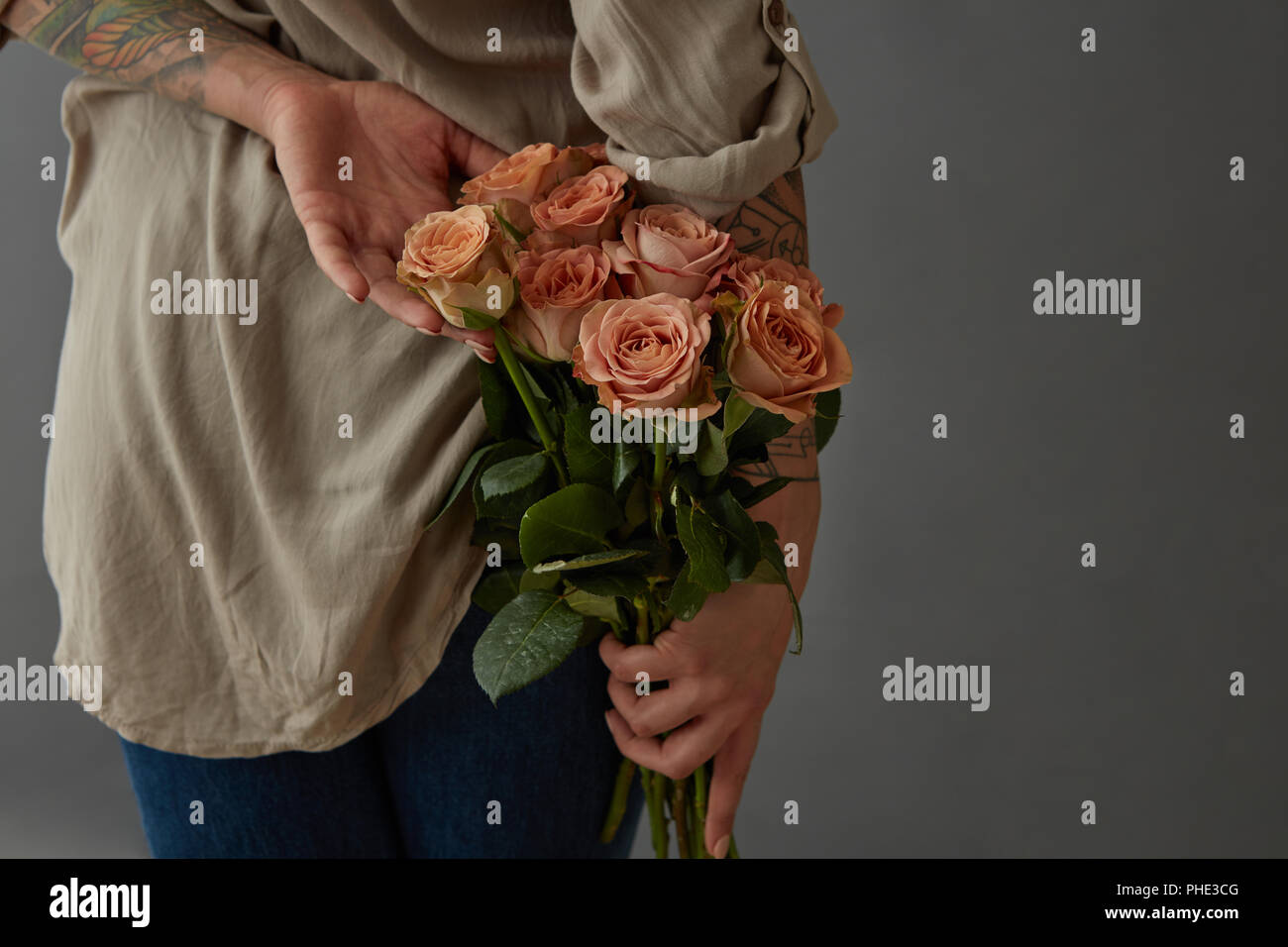 Bellissima ragazza con un cappuccino rose dietro la schiena. Foto Stock