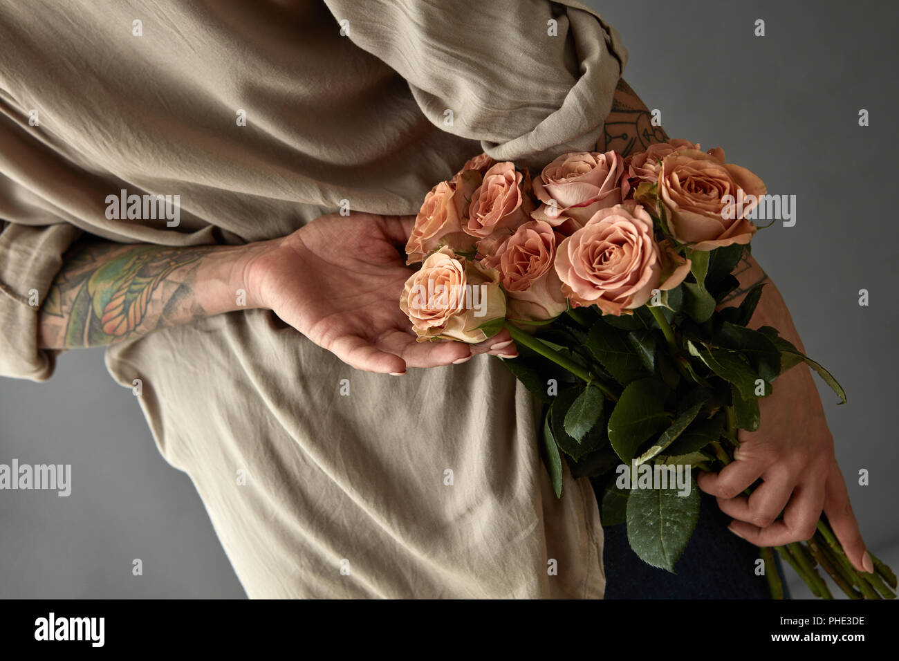 Bellissima ragazza con un cappuccino rose dietro la schiena. Foto Stock