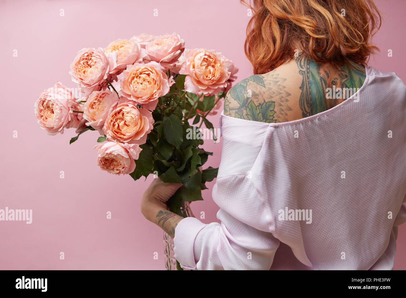 Ragazza con un grande mazzo di rose rosa Foto Stock