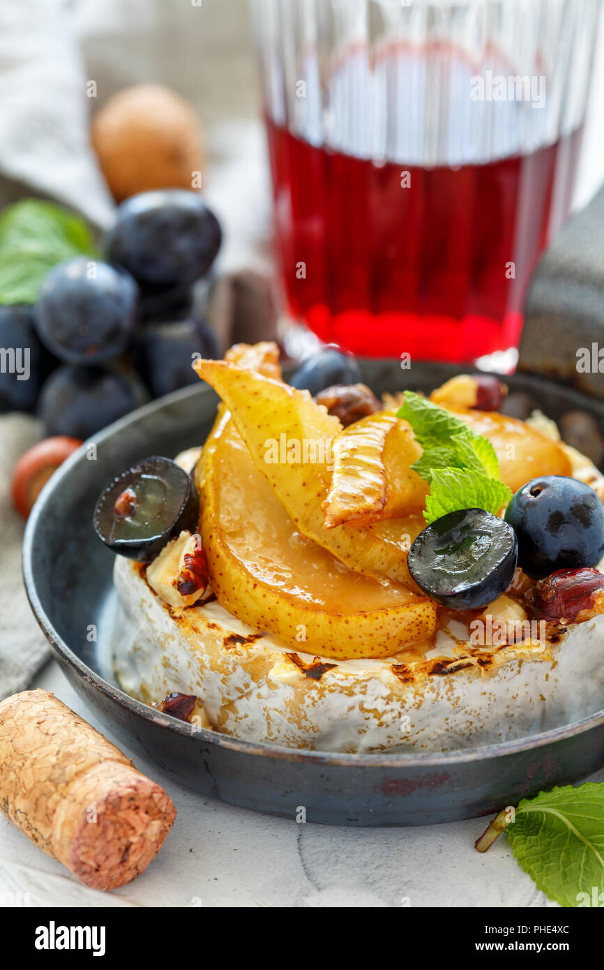 Camembert al forno con le pere e le uve. Foto Stock