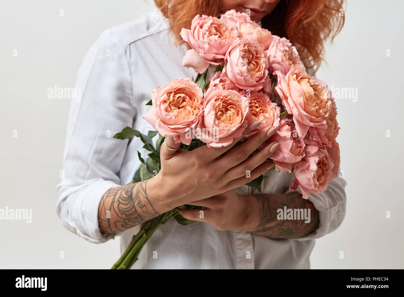La ragazza è in possesso di un bouquet di rose rosa Foto Stock