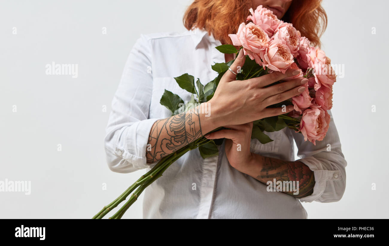 La ragazza è in possesso di un bouquet di rose rosa Foto Stock