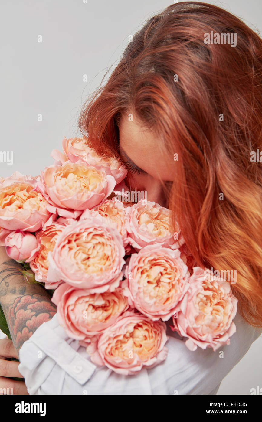 Bella ragazza tenendo un bouquet di rose rosa Foto Stock