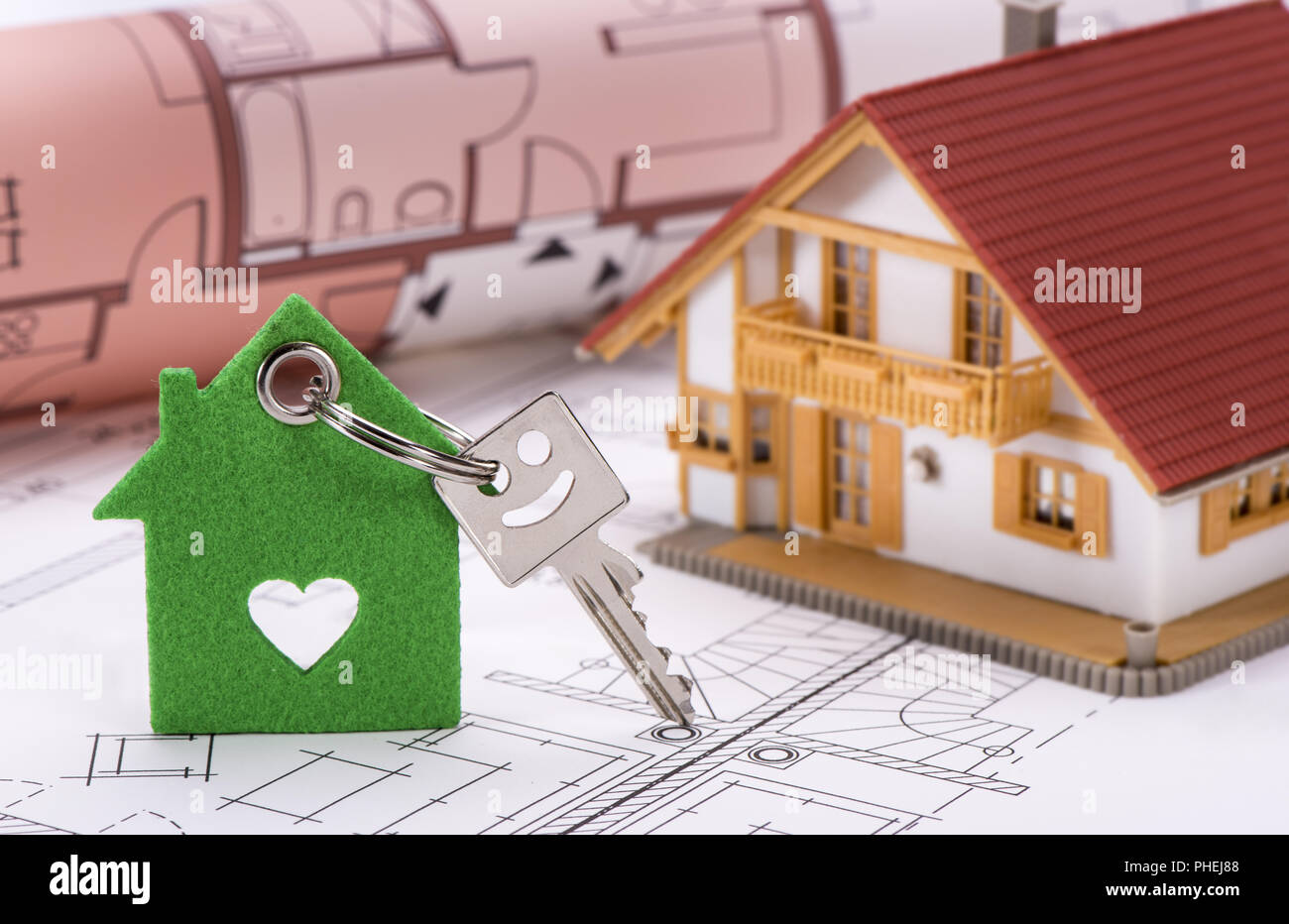 Chiave di casa sul piano di costruzione con il modello di casa Foto Stock