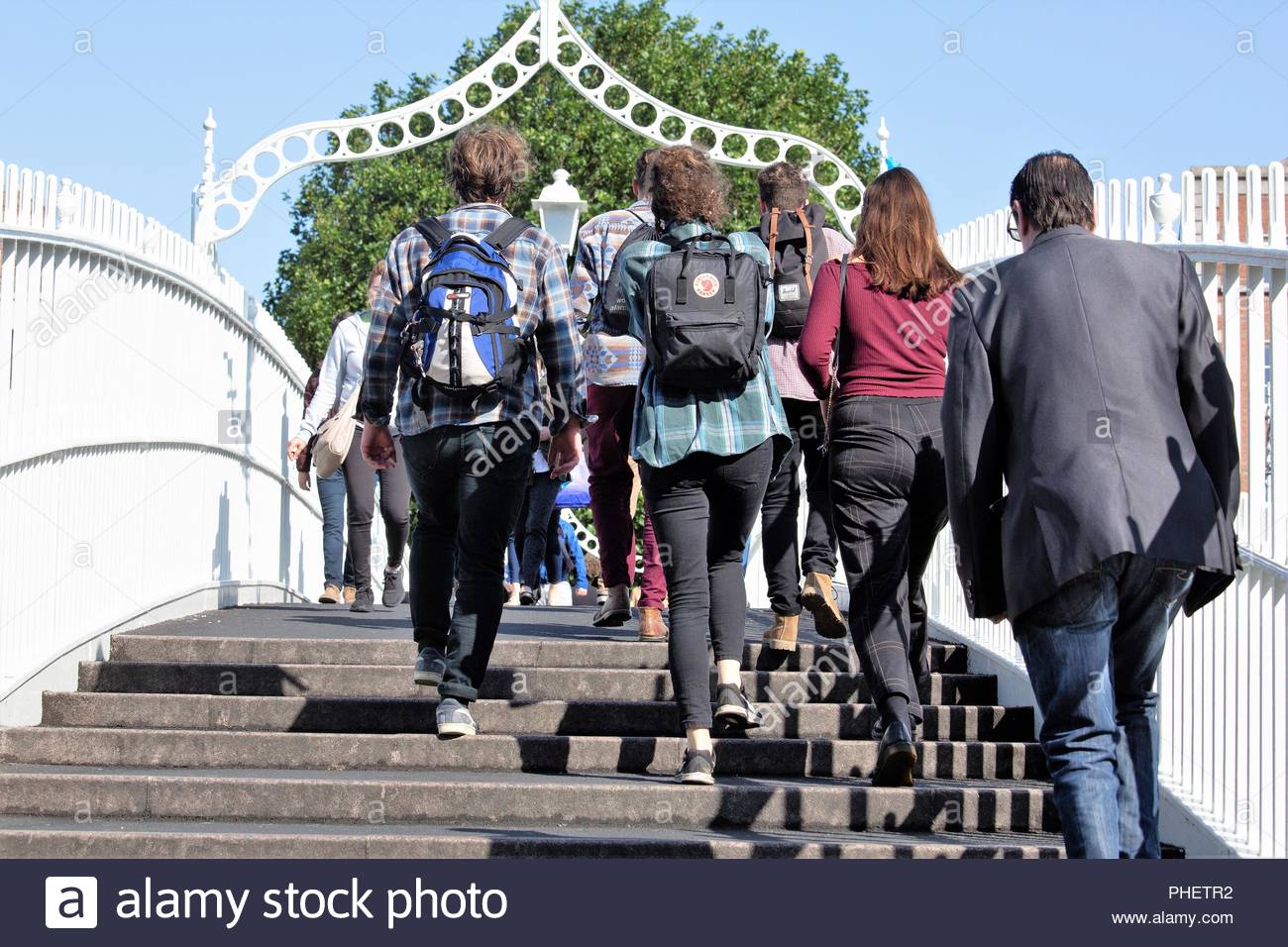 Le persone che attraversano la Ha'penny Bridge a Dublino come il numero di turisti in Irlanda continua a crescere Foto Stock