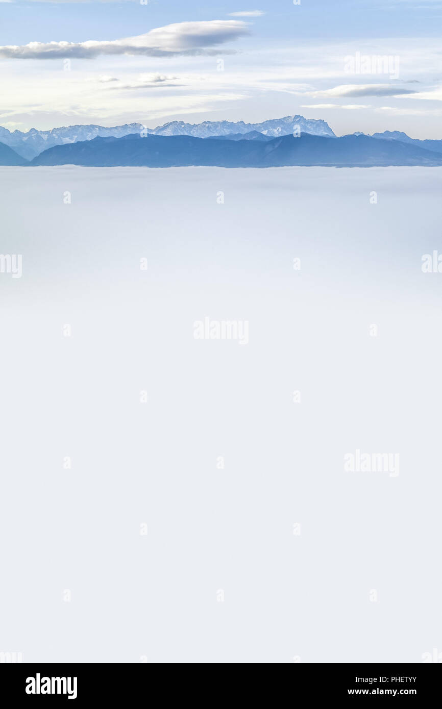 Paesaggio coperto di nebbia con le alpi in background Foto Stock