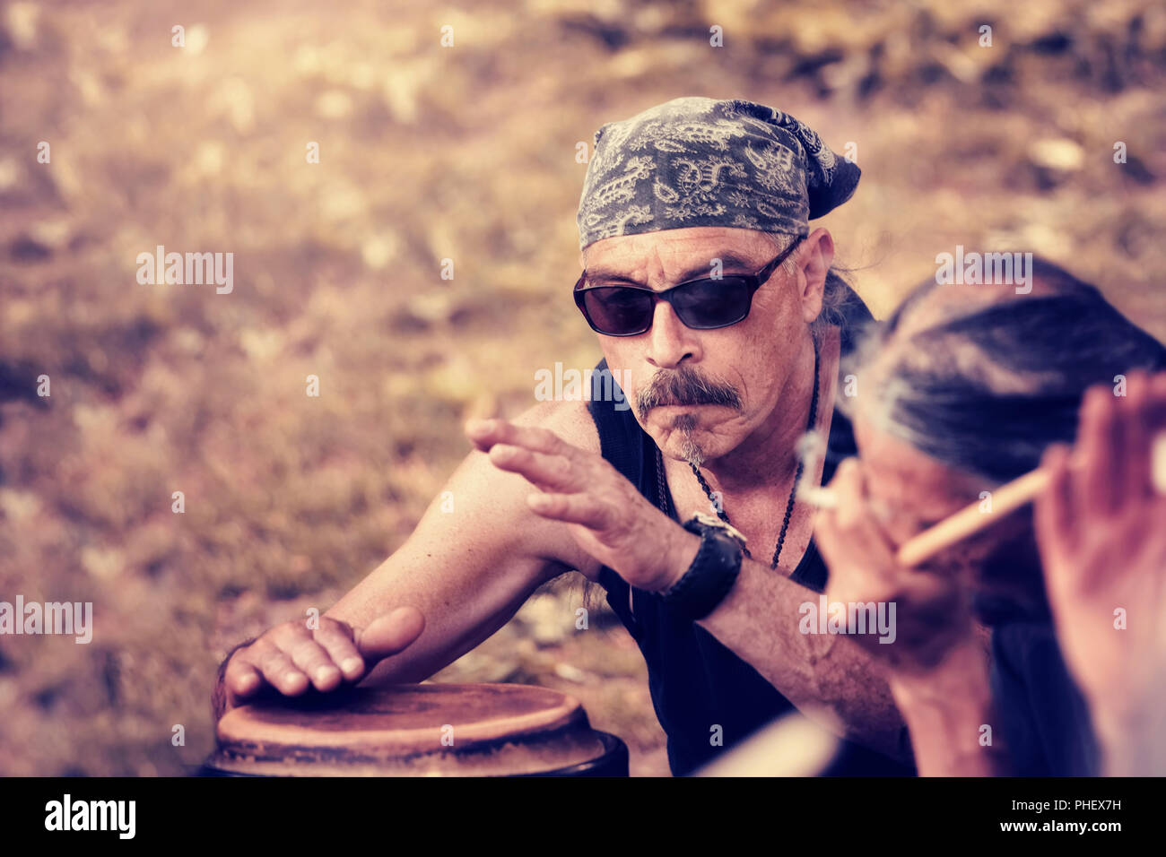 Cool Latino medioevo uomo che indossa una bandana gioca ritmo con djembe tamburo bongo in un rito indigeni a Montreal, Quebec, Canada. Foto Stock