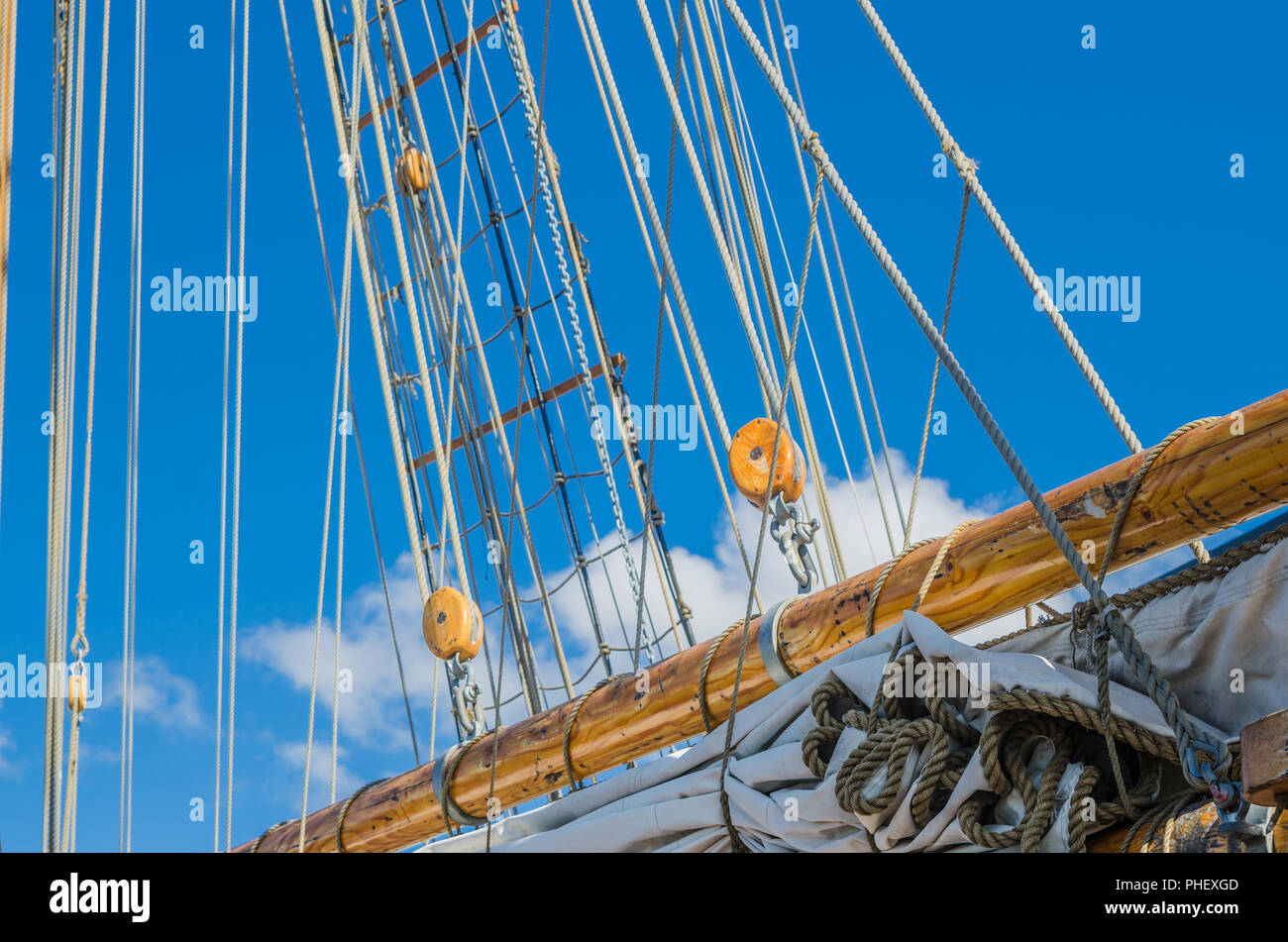 Vela ripiegata e montante su una vecchia barca a vela Foto Stock