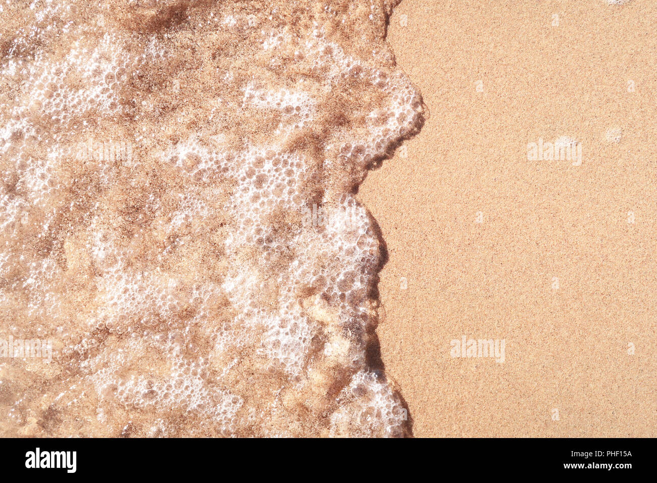 Onda sulla spiaggia sabbiosa Foto Stock