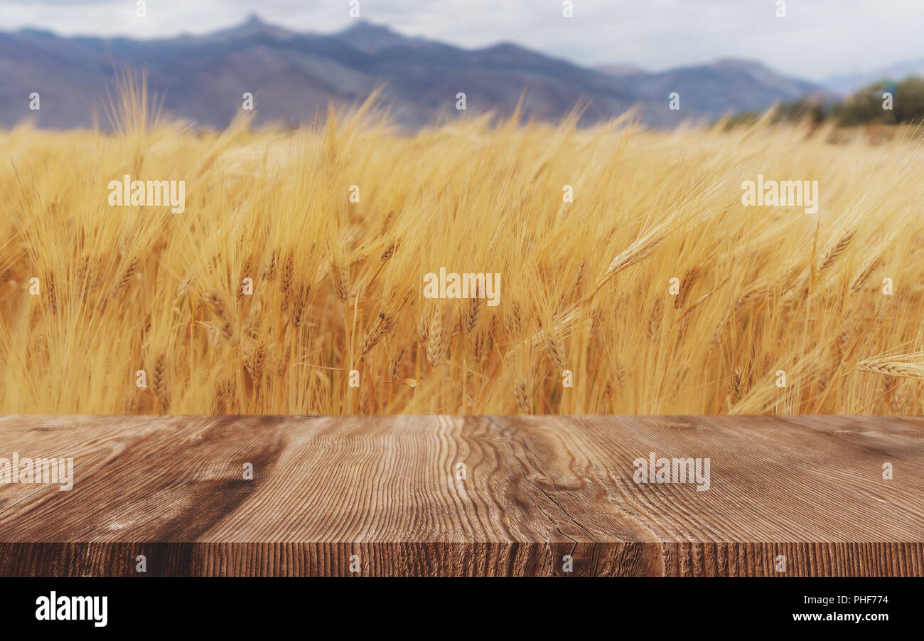 Spighe di grano dello sfondo dei campi maturi il raccolto di grano con pavimento in legno Foto Stock