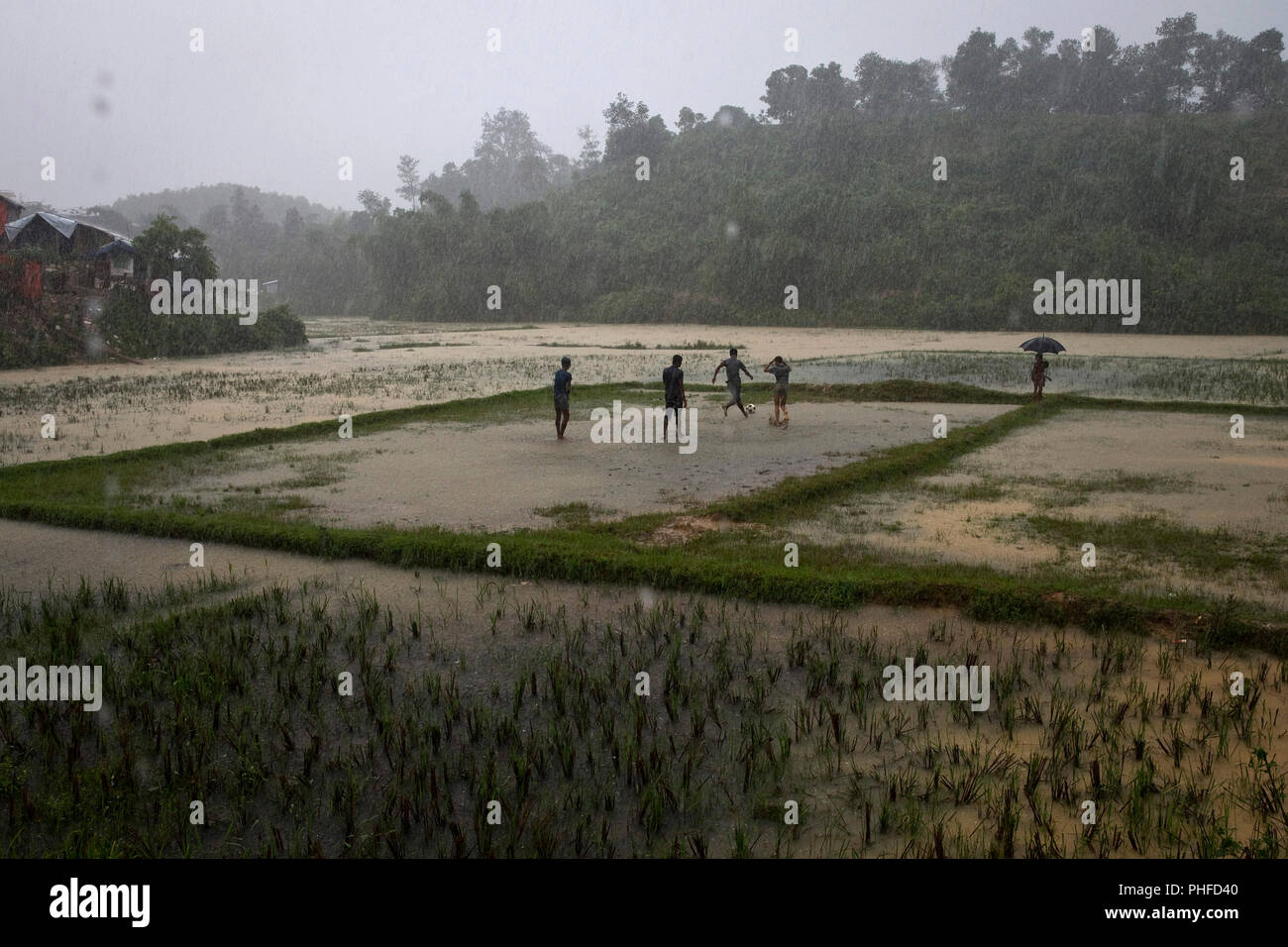 Rohingya uomini giocare a calcio in un campo inondato in Charkmakul, uno dei campi per il ricovero di oltre 800.000 profughi Rohingya, Cox's Bazar, Bangladesh, giugno 1 Foto Stock
