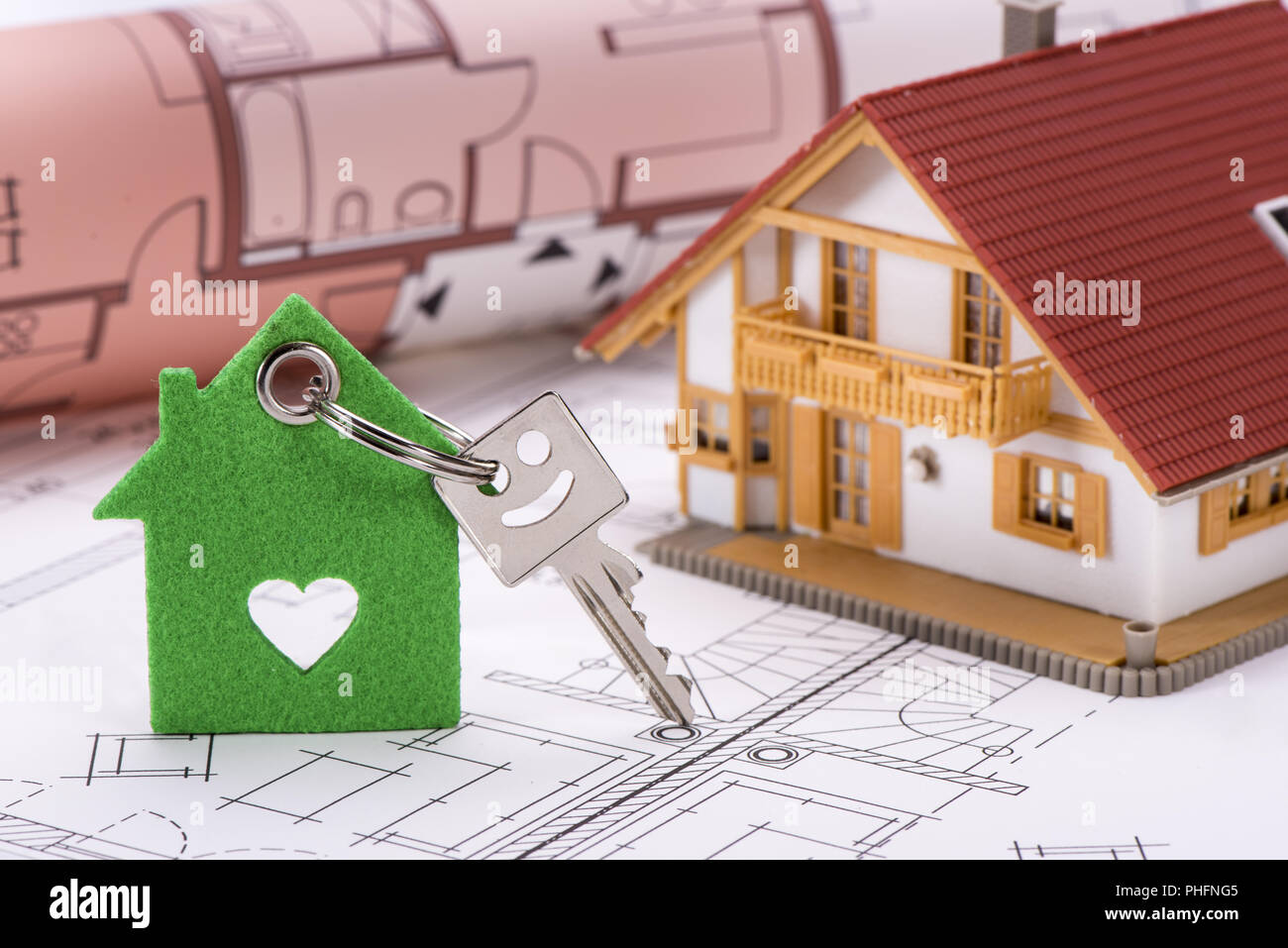 Chiave di casa sul piano di costruzione con il modello di casa Foto Stock