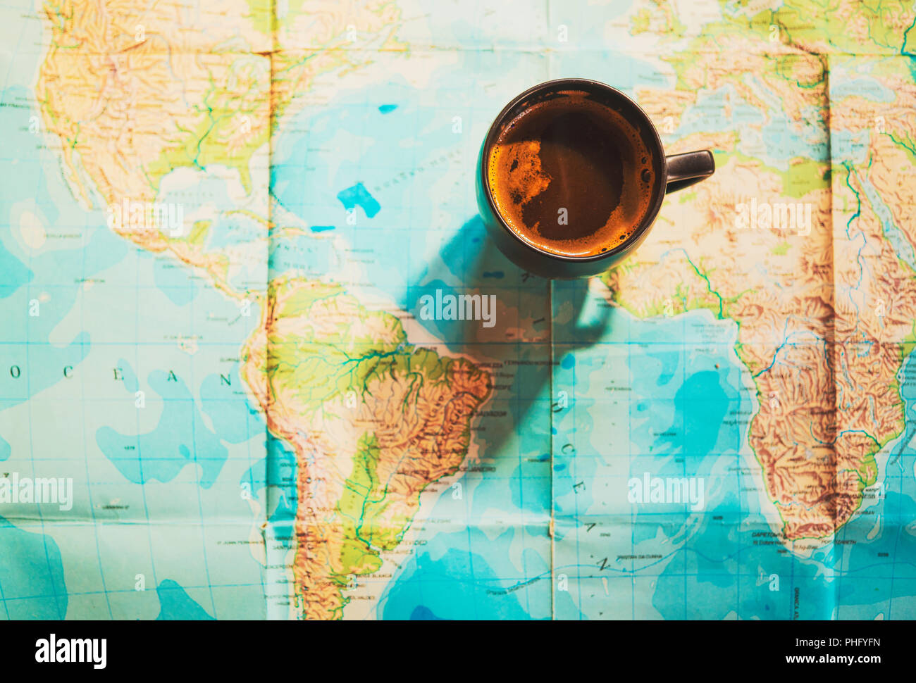 Bella tazzina di caffè con la mappa del mondo in background; immagine concettuale di viaggio viaggi planante con mappa del mondo; viaggi sfondo correlati Foto Stock
