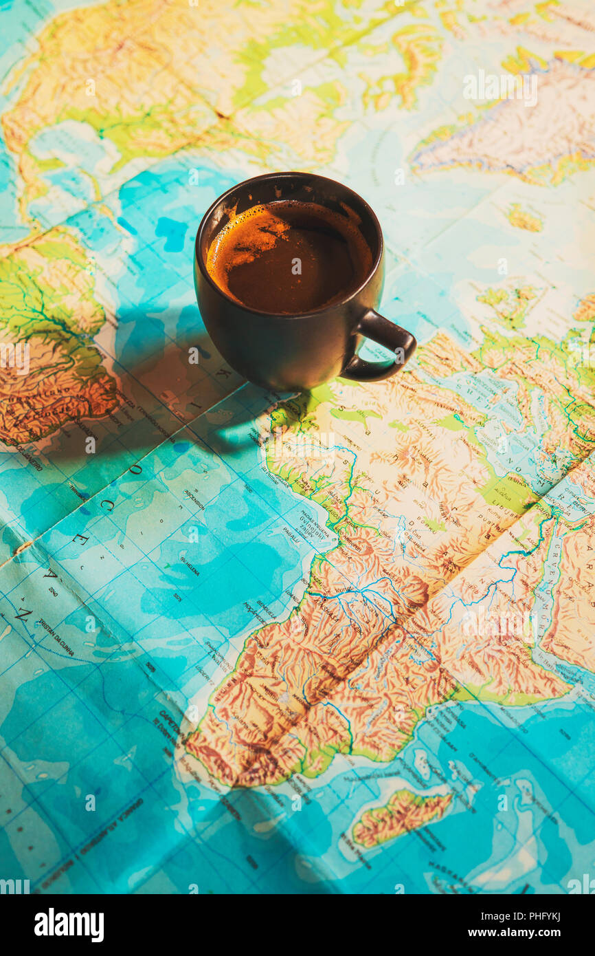 Bella tazzina di caffè con la mappa del mondo in background; immagine concettuale di viaggio viaggi planante con mappa del mondo; viaggi sfondo correlati Foto Stock