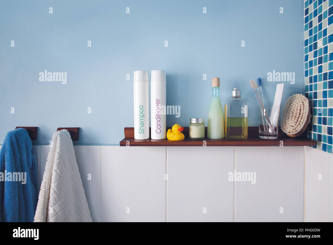 Parete blu e un ripiano in bagno con accessori igiene Foto Stock