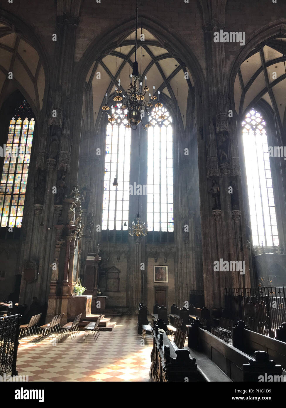 I raggi del sole illuminano gli archi di una vecchia cattedrale cattolica all'interno Foto Stock