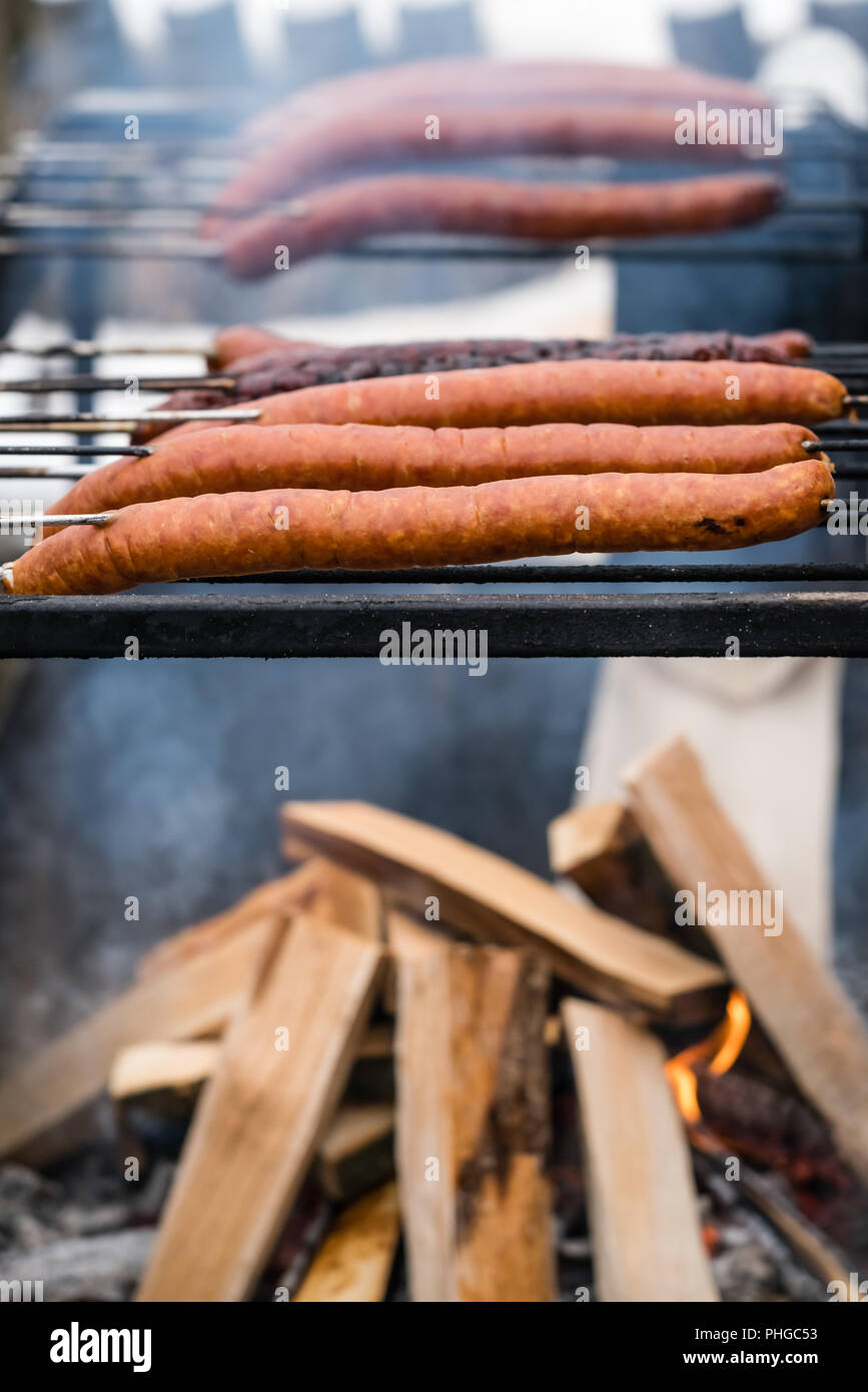 La carne di maiale e manzo salsicce alla griglia essendo Foto Stock