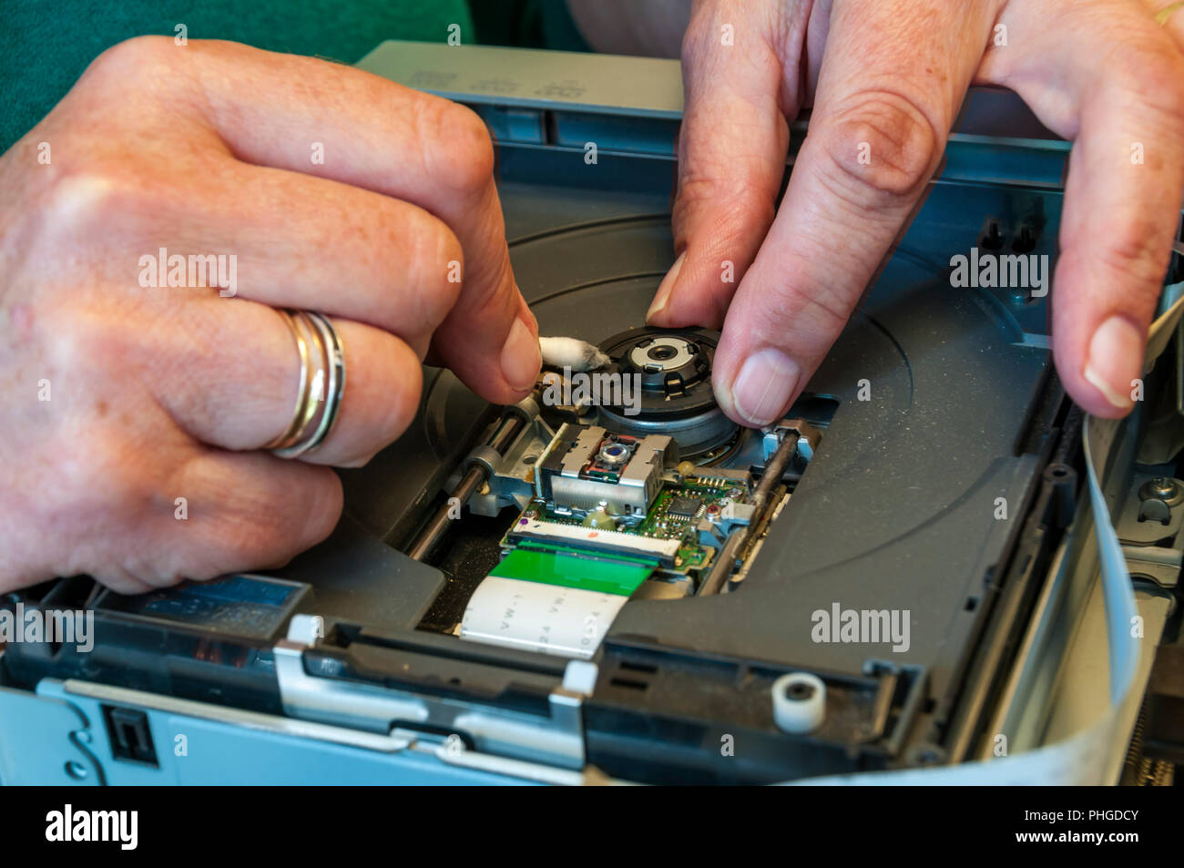Pulizia del tecnico il mandrino di un registratore DVD con un batuffolo di cotone. Foto Stock