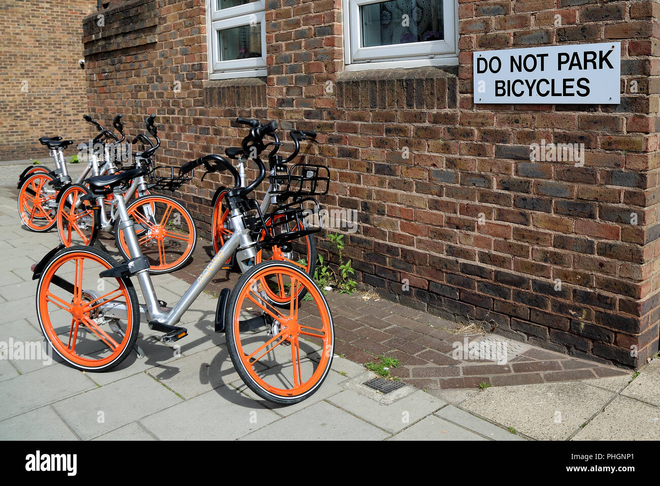 Diverse biciclette parcheggiate al di sotto di un divieto di avviso al di fuori di un edificio in St Aldates, Oxford, Regno Unito Foto Stock