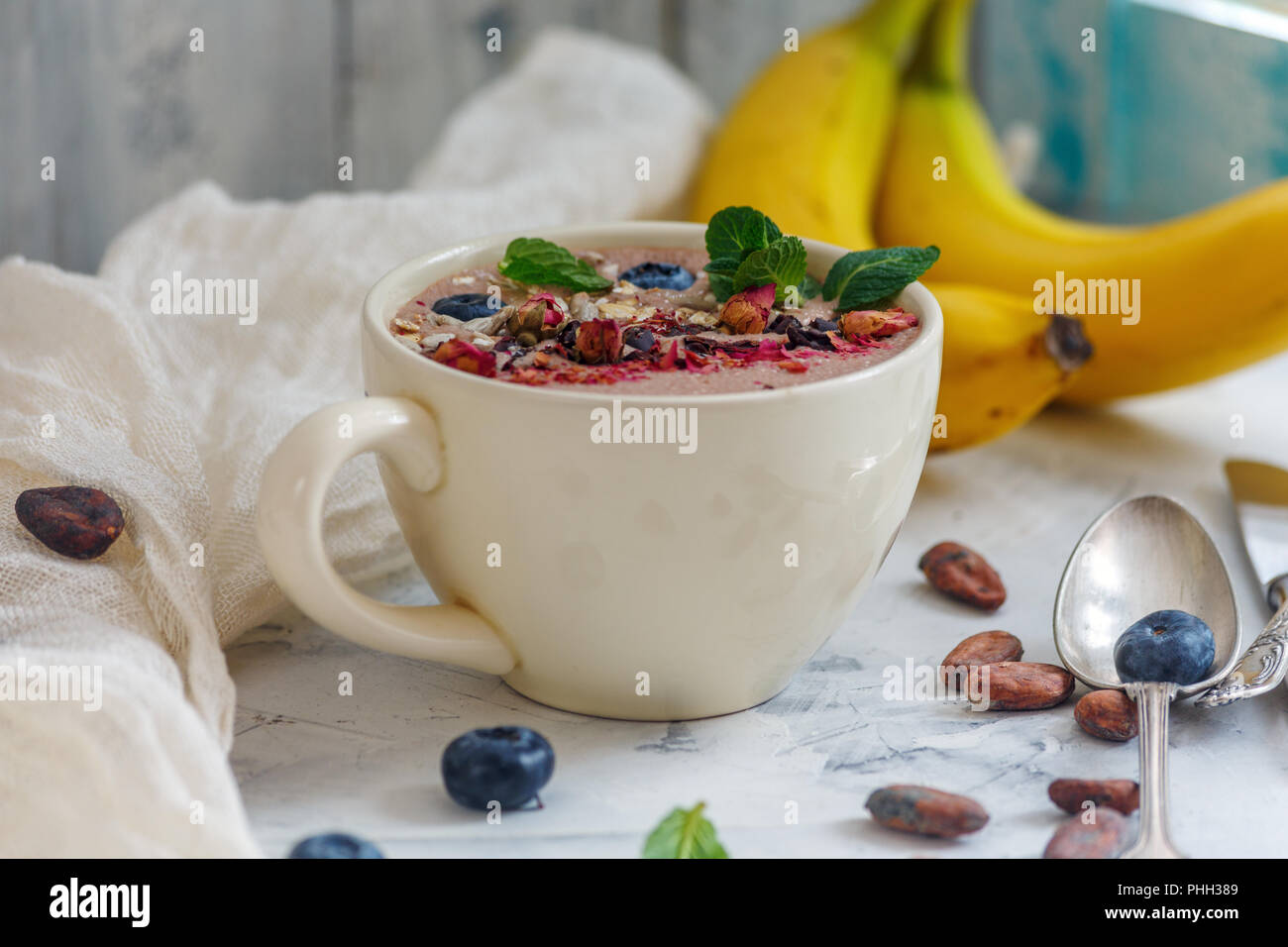 Ciotola frullato al cioccolato, le fave di cacao e mirtilli. Foto Stock