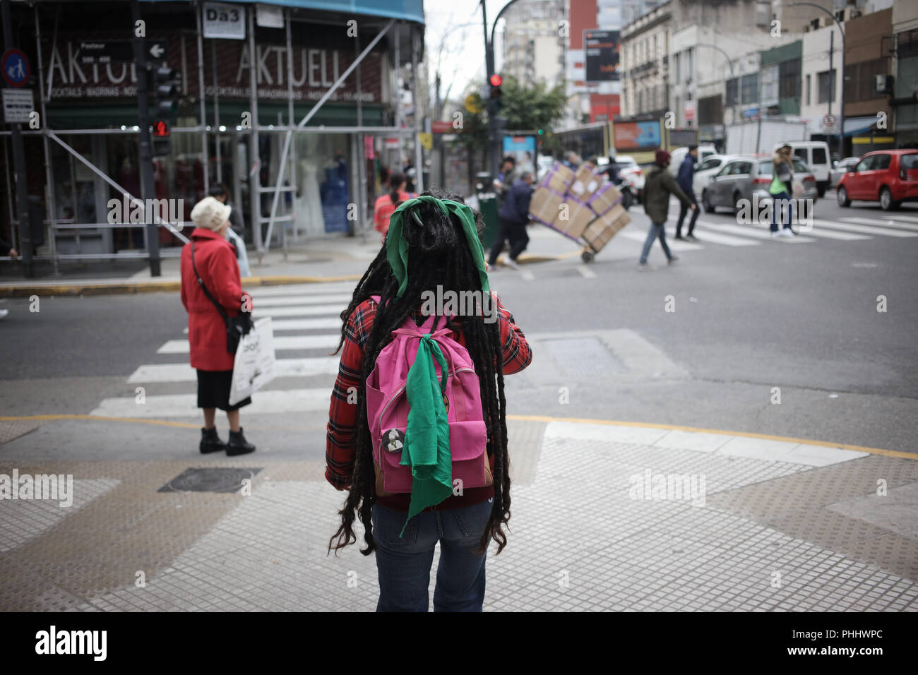 La donna non identificato a piedi lungo Avenida Corrientes portante un pro aborto fazzoletto di verde legato nel suo zaino in Buenos Aires, Argentina Foto Stock