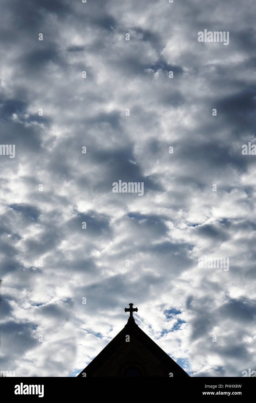 Le nubi riempiono il cielo sopra la croce di pietra sulla cima di San Francesco nella Cattedrale di Santa Fe, New Mexico USA Foto Stock