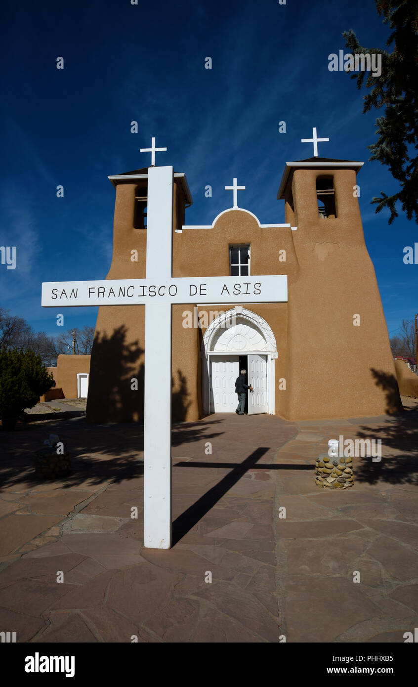 Un turista entra la storica adobe San Francisco de Asis chiesa della Missione in Rancho de Taos, Nuovo Messico USA Foto Stock
