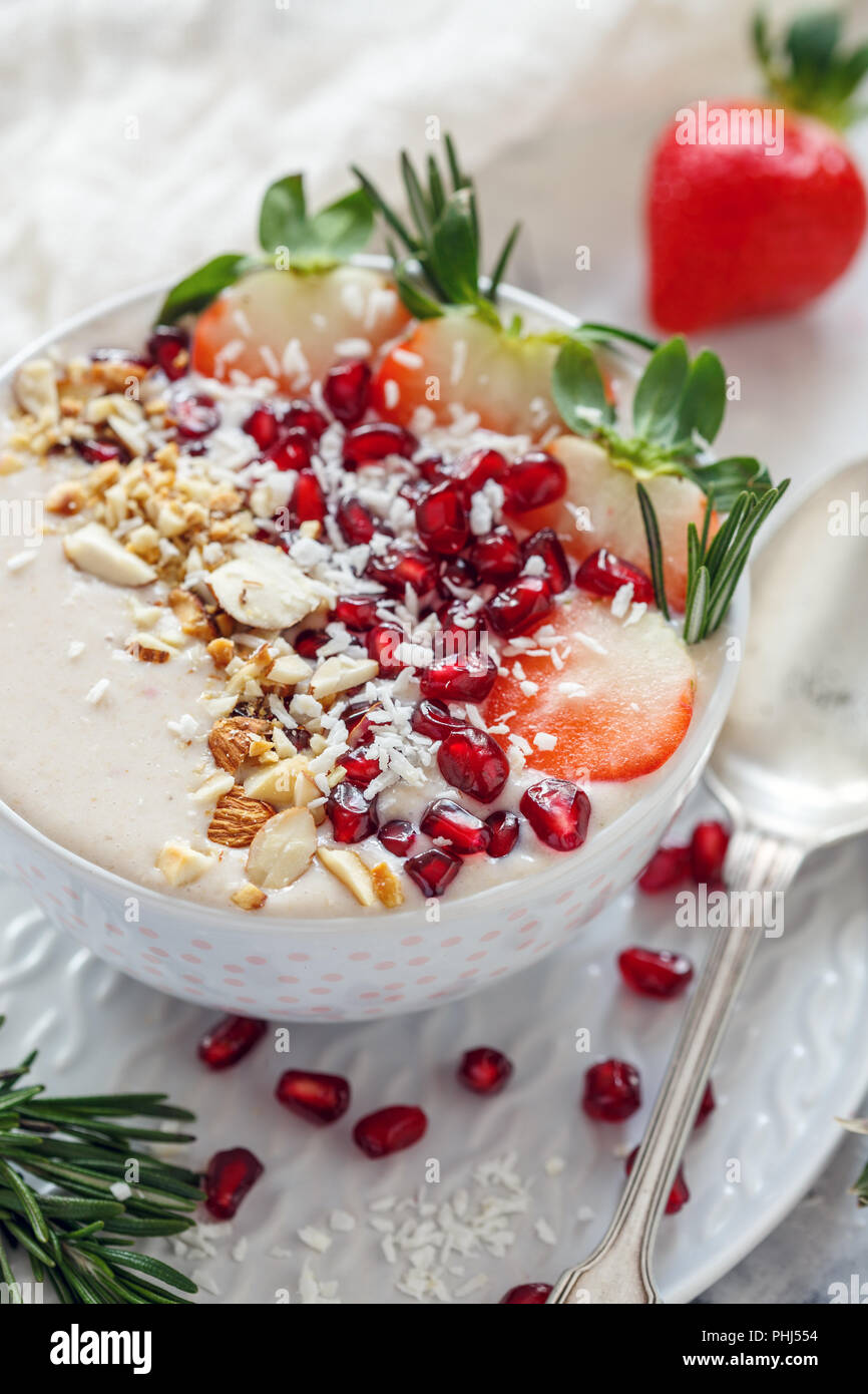 I frullati ciotola con fragole, melograno, dadi. Una sana prima colazione. Foto Stock