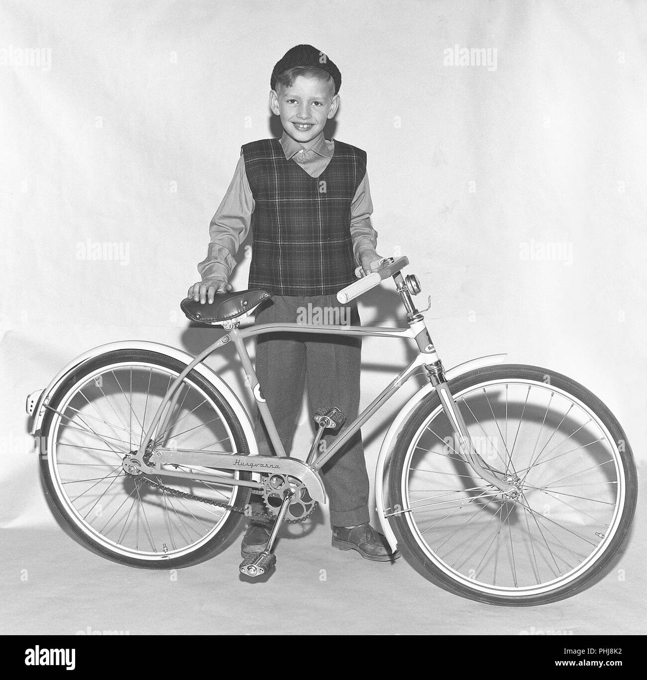 1950s bicicletta. Un ragazzo con una bicicletta per bambini nuova di zecca del produttore Husqvarna. Svezia 1955. Rif BV40-12 Foto Stock