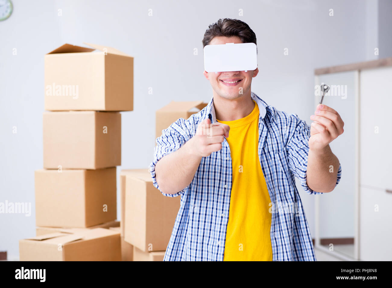 Giovane uomo che indossa gli occhiali VR muovendo in un nuovo appartamento Foto Stock