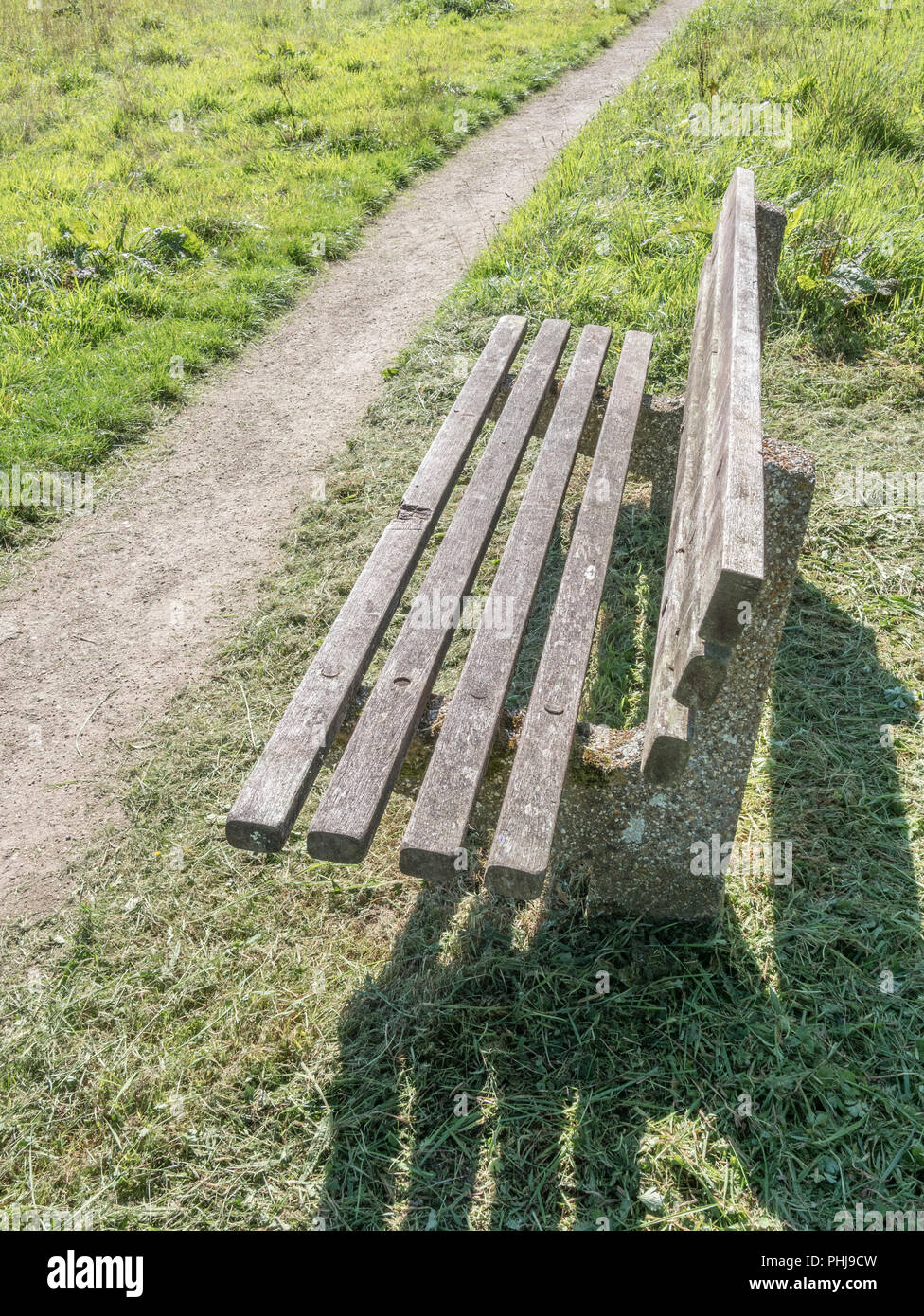 Sedile a panchetta in uno spazio pubblico vuoto nelle giornate di sole. Metafora Covid-19 blocco. Covid Park panca riunioni, posti vuoti durante Covid nel Regno Unito. Foto Stock