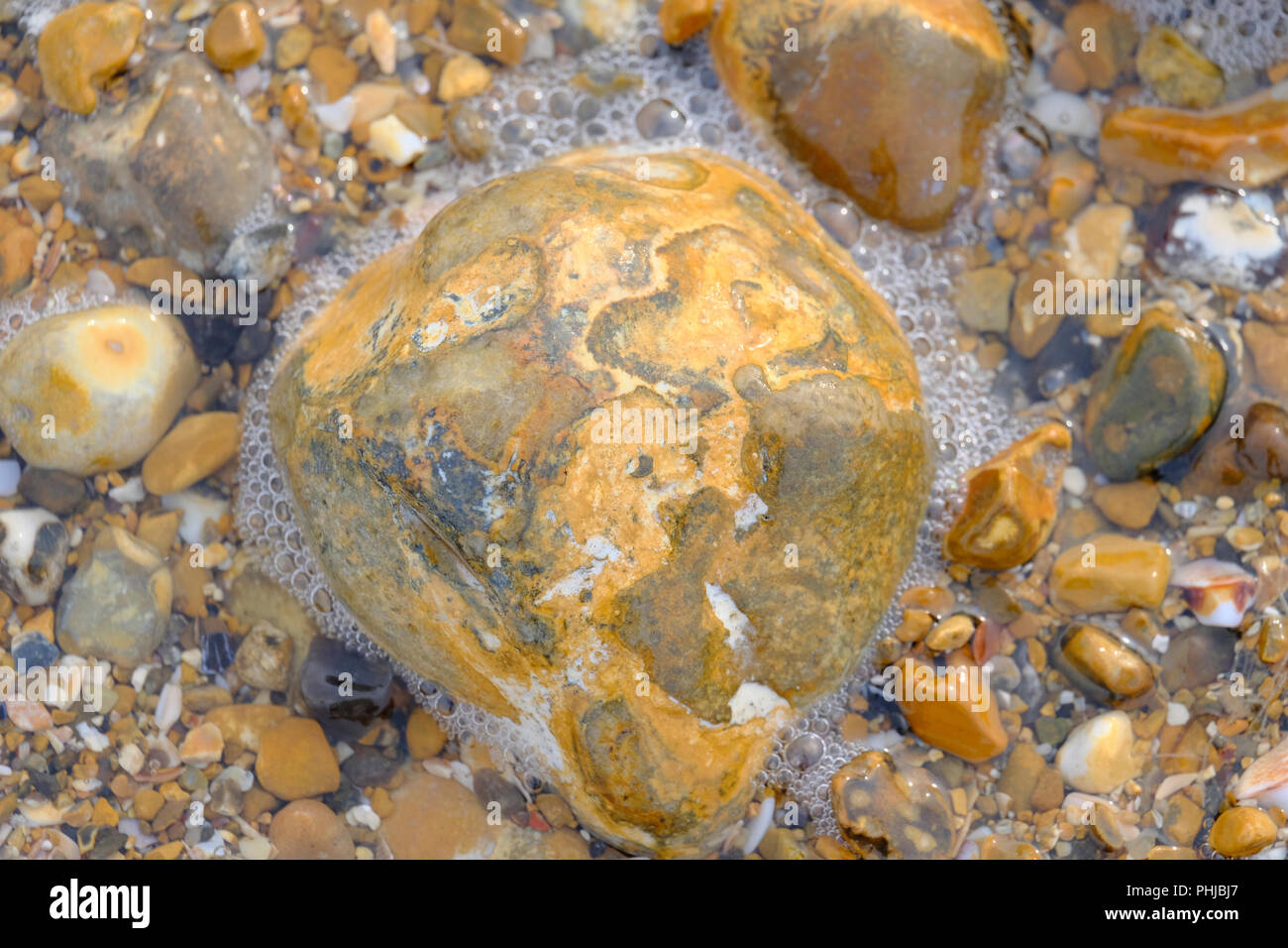 A forma di cuore sulla roccia spiaggia ghiaiosa con la bassa marea. East Preston, West Sussex Foto Stock