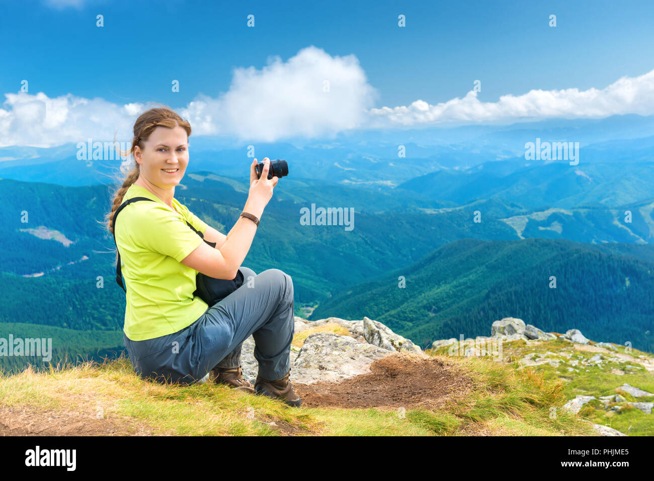Giovane donna seduta sulle montagne cliff Foto Stock