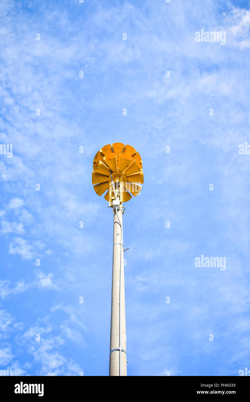 fotografia di diverse sirene di emergenza amplificate gialle rotonde multidirezionali sulla cima di un palo in una piccola città Foto Stock