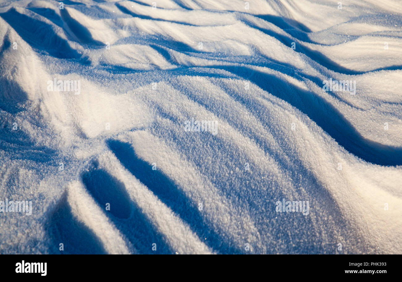 Soleggiato derive di neve struttura ondulata in inverno freddo, primo piano Foto Stock