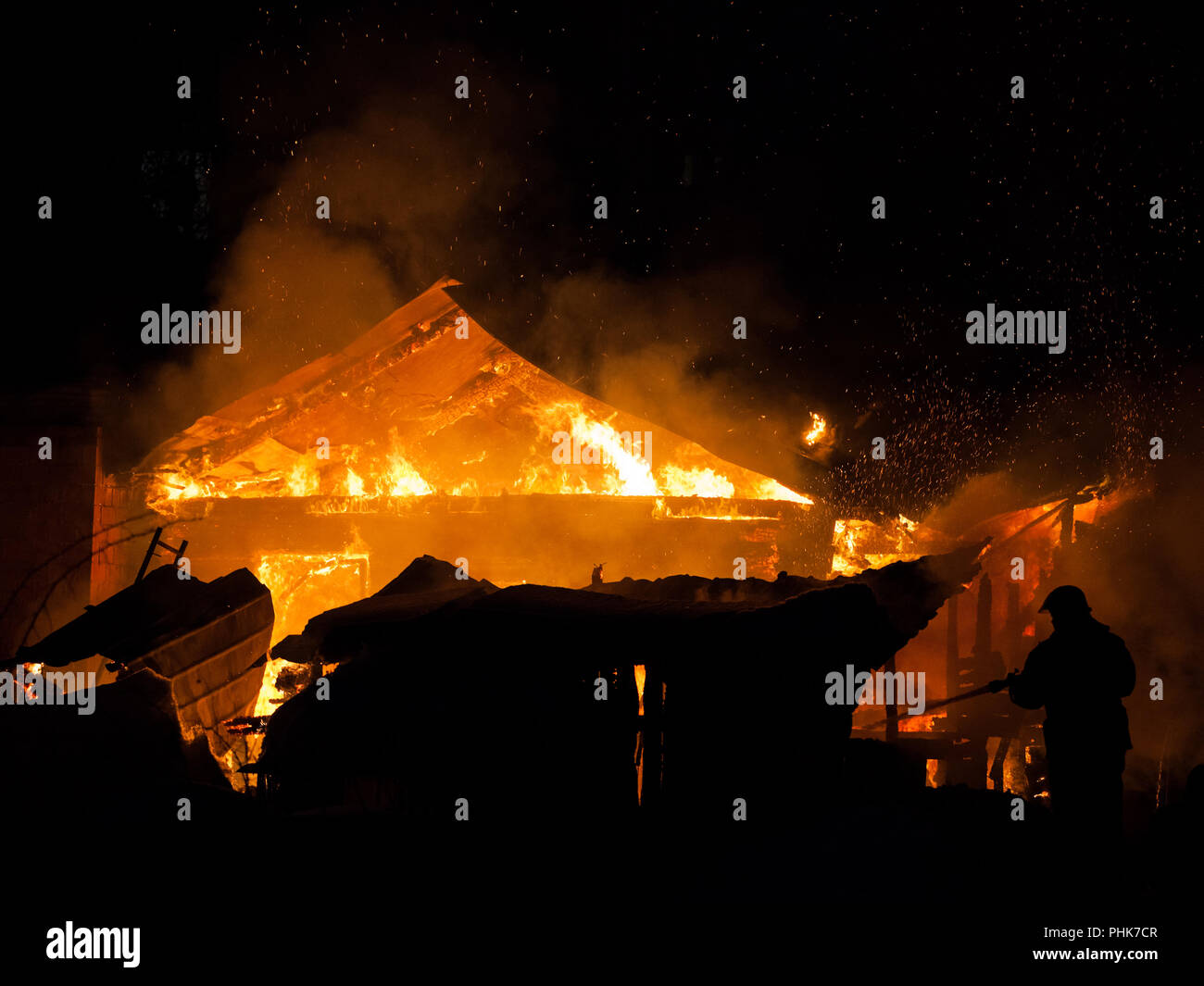 Vigile del fuoco a fuoco ardente fiamma su casa in legno tetto Foto Stock