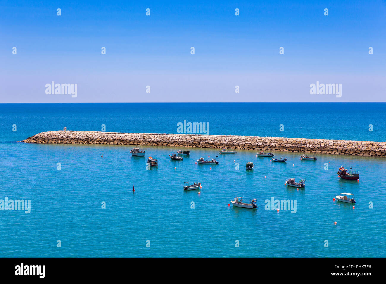 Molte piccole imbarcazioni che giace vicino al molo in mare Foto Stock