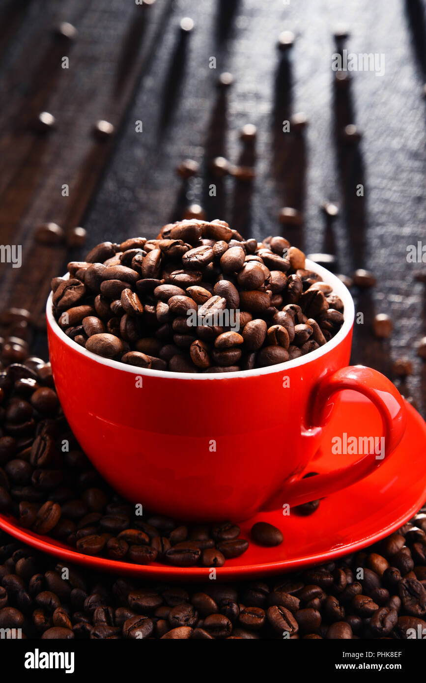 Composizione con Rosso tazza di caffè e fagioli. Foto Stock